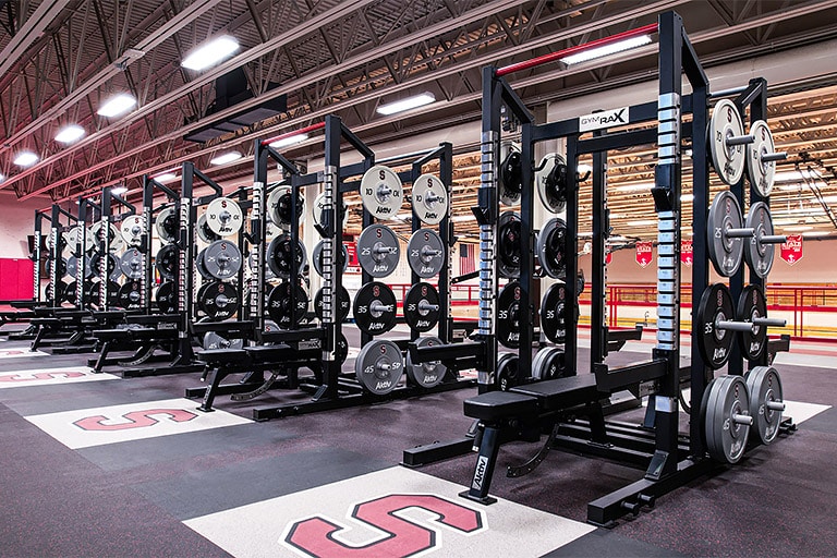 Forma Olympic racks with branded Olympic plate strength equipment.