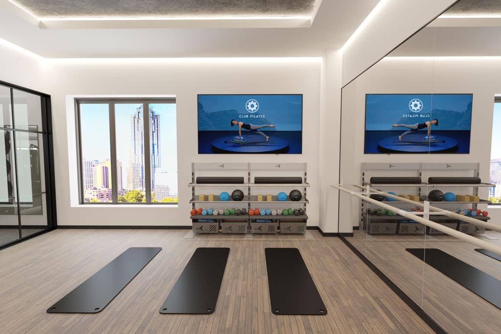 Xponential+ Functional Fitness on gym TV in amenity room with two Gym Rax storage bays and 3 mats.