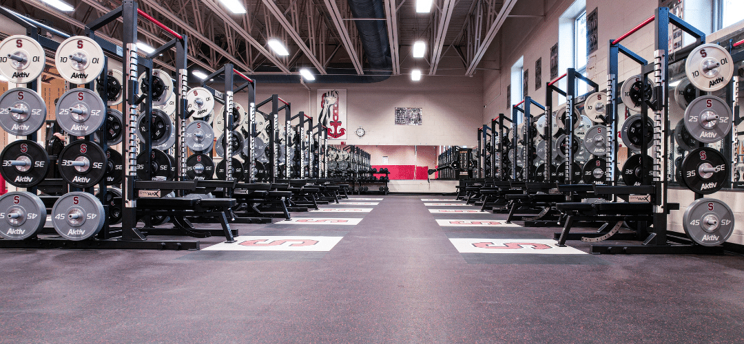 High school weight room with custom gym flooring and olympic racks