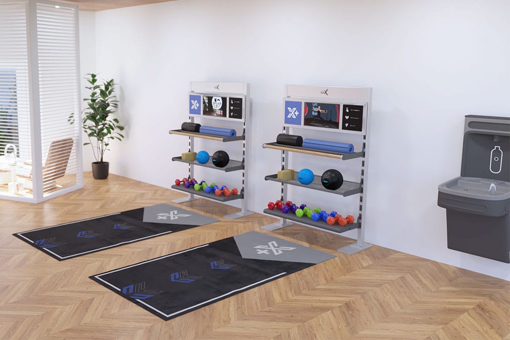 Two sets of Double Xponential+ Training Bays with digital exercise guidance on the wall and gym flooring.